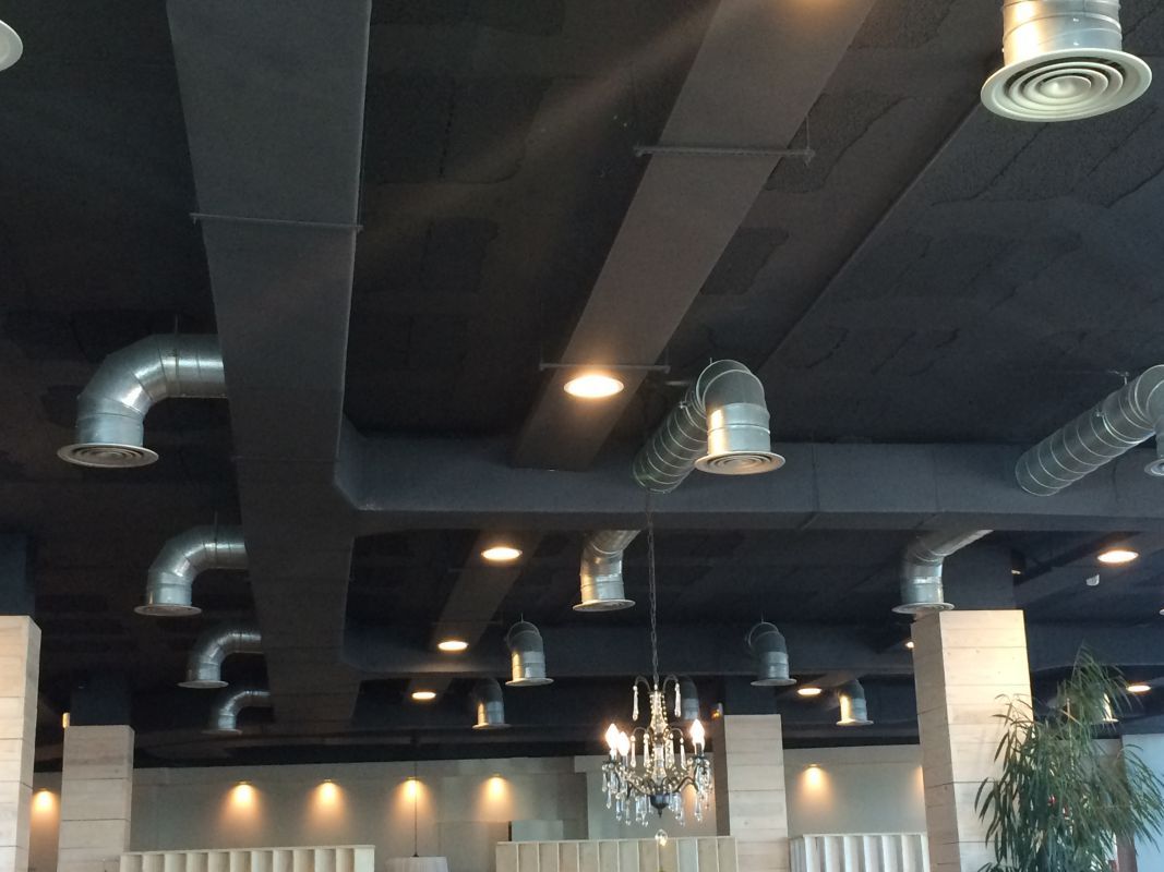 Instalación especializada de conductos de chapa y fibra en locales, proporcionando un sistema de climatización efectivo y rentable.