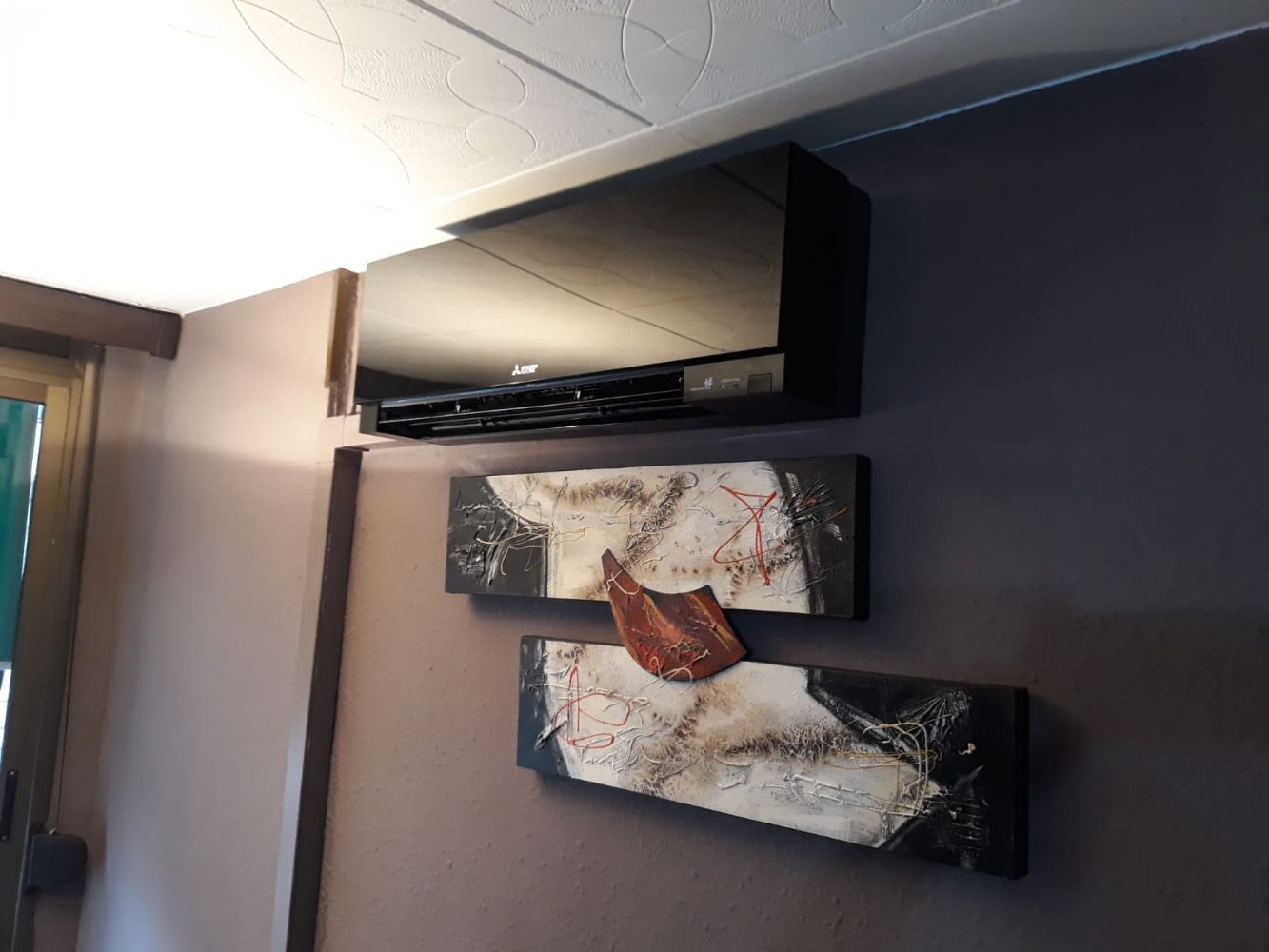 Instalación doméstica de un aire acondicionado split color negro en habitación aire acondicionado por split Mitshubisi en Sabadell